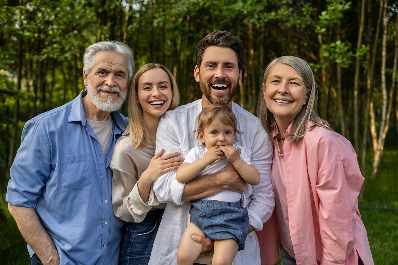 Junge Familie mit Kind auf dem Arm und dem Großvater daneben