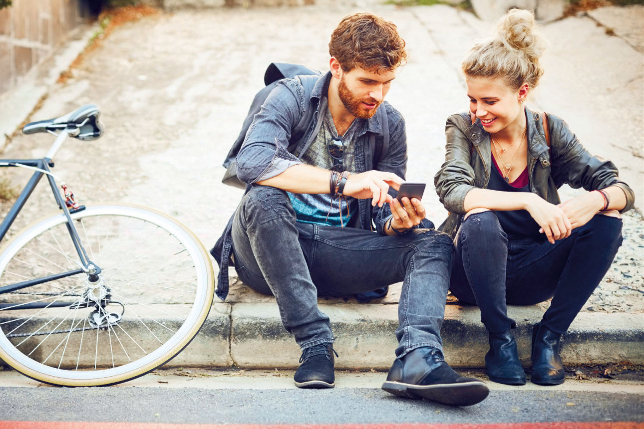 Junge Frau und junger Mann sitzen auf Treppe