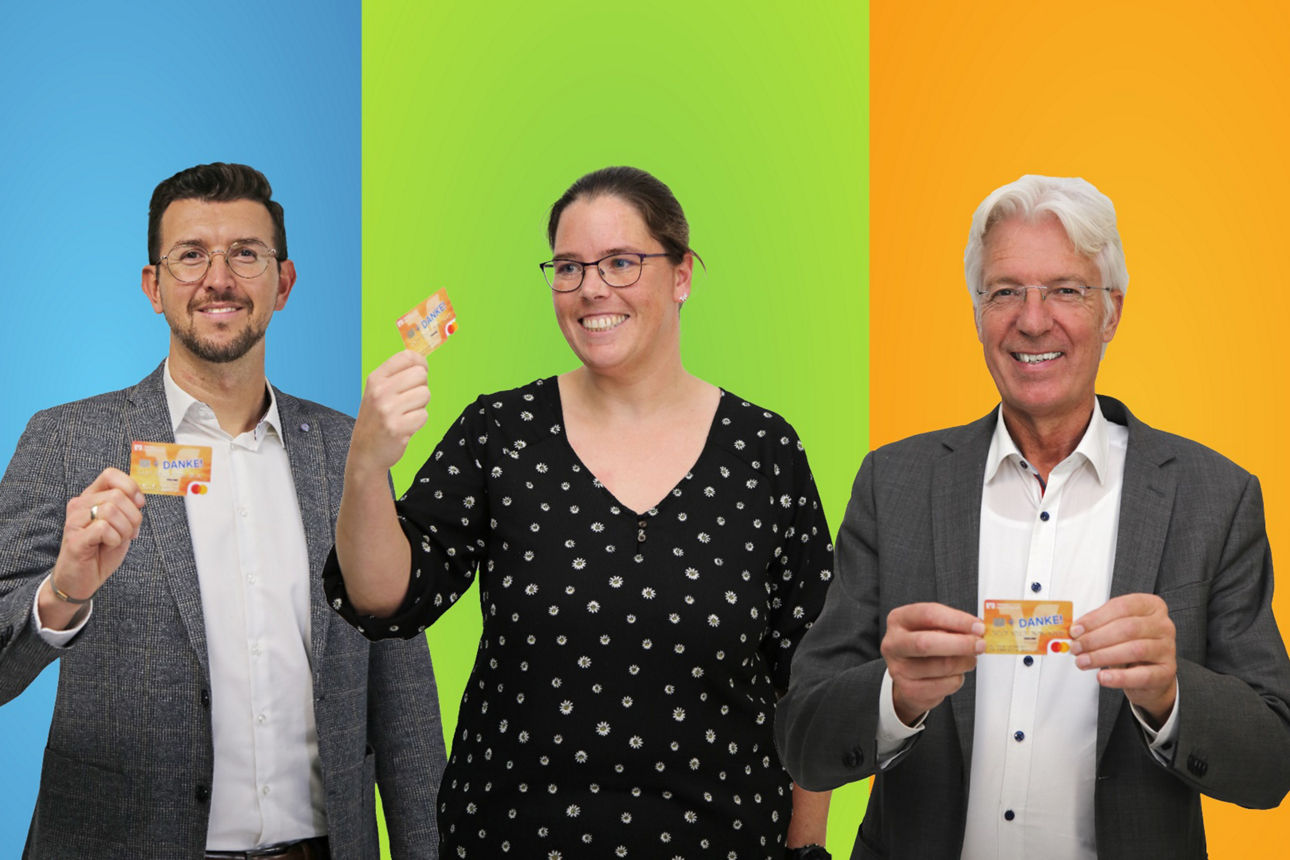 Zwei Männer und eine Frau halten die Givve Card in die Kamera
