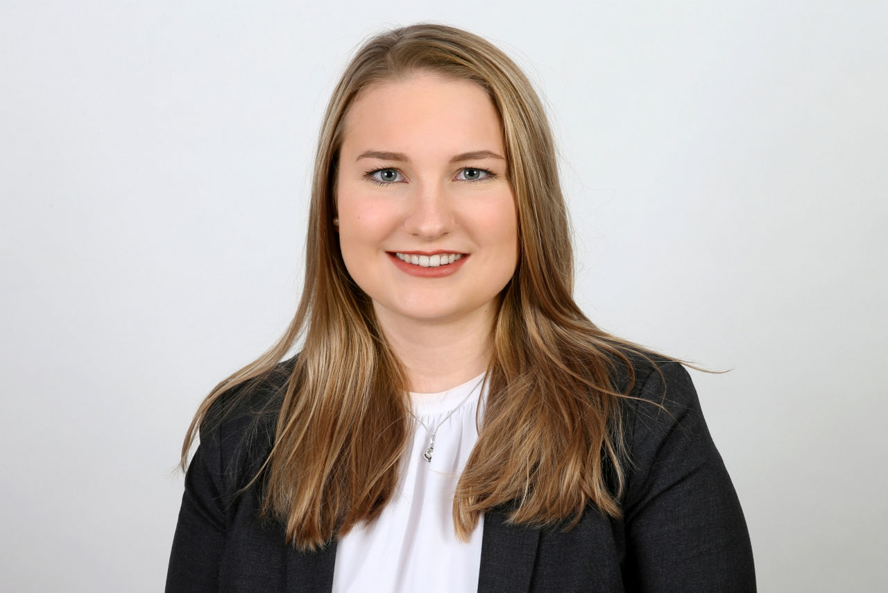 Eine lächelnder Frau schaut in die Kamera.