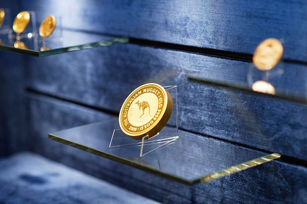 Goldmünzen, beleuchtet in Vitrine, fokussiert auf Münze namens Australien Nugget mit geprägtem Känguruh