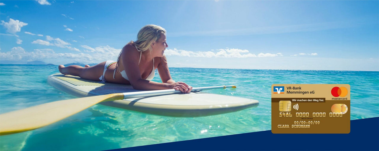 Blonde Frau auf einem Surfbrett liegend