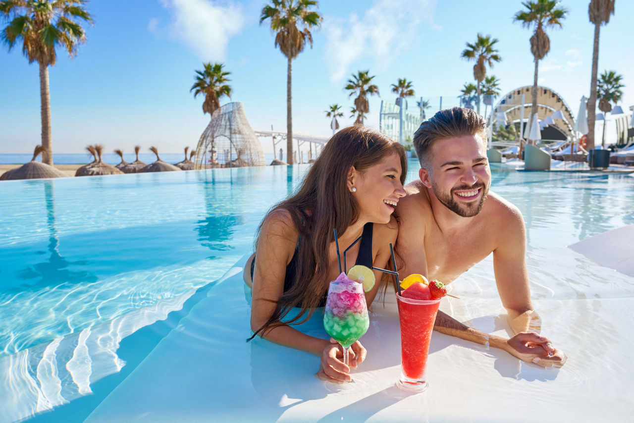 Zwei Personen sitzen im Pool und trinken Cocktails