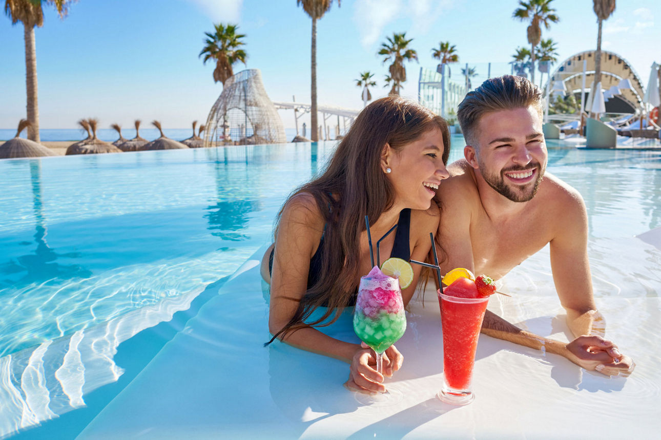 Zwei Personen sitzen im Pool und trinken Cocktails
