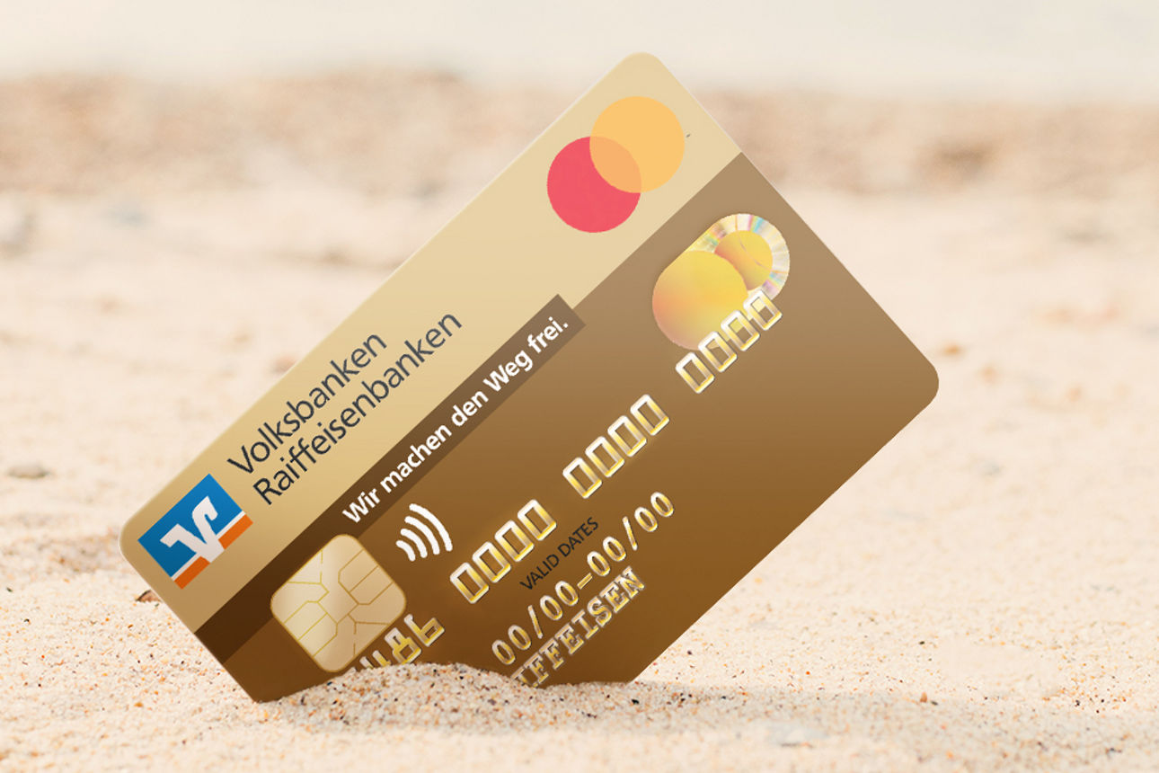 Mastercard Goldcard steck in einem Sand am Meer