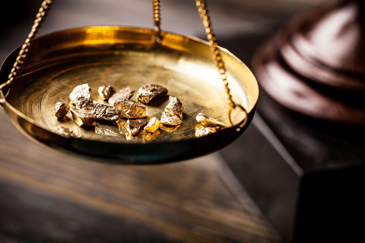 Eine Goldwaage, auf der Goldnuggets gewogen werden