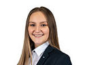 Ansprechpartnerin Ida Gomm in einem Business Outfit lächelt in die Kamera