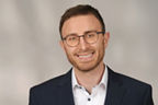 Stephan Gorges hat kurze braune Haare und eine halbrunde Brille. Er trägt einen Anzug