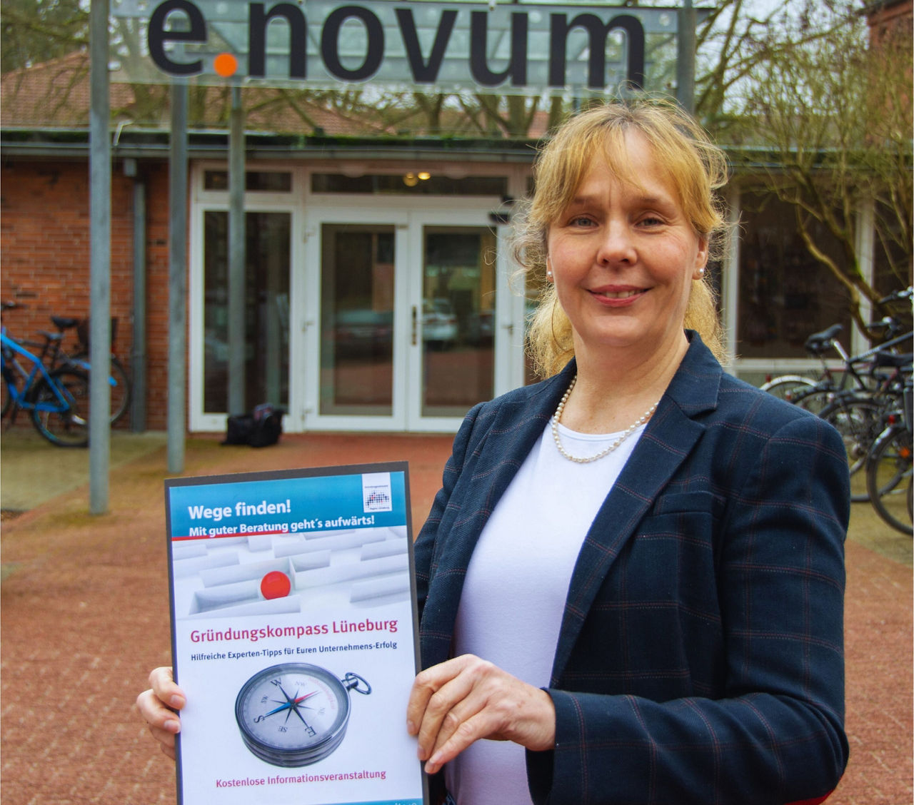 Eine Frau hält ein Plakat vom Gründungskompass in den Händen