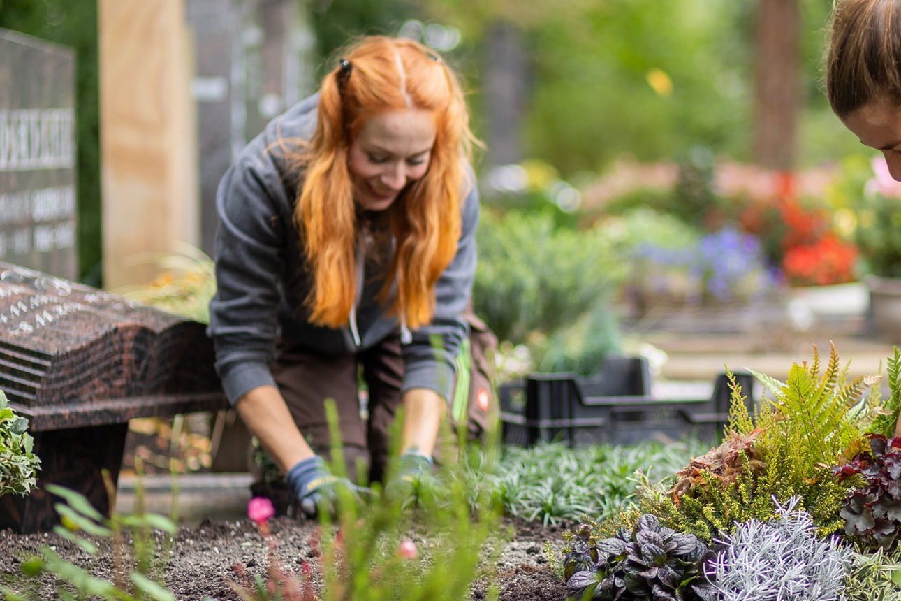 Zwei junge Frauen bei der Grabpflege