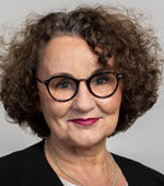 Frau mit braunen lockigen Haaren und Brille.