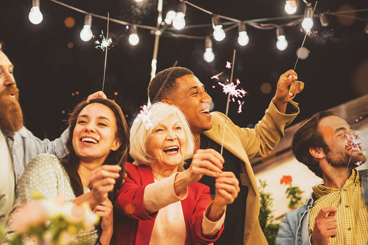 Familie und Freunde feiern Neujahr auf einer Dachterrasse