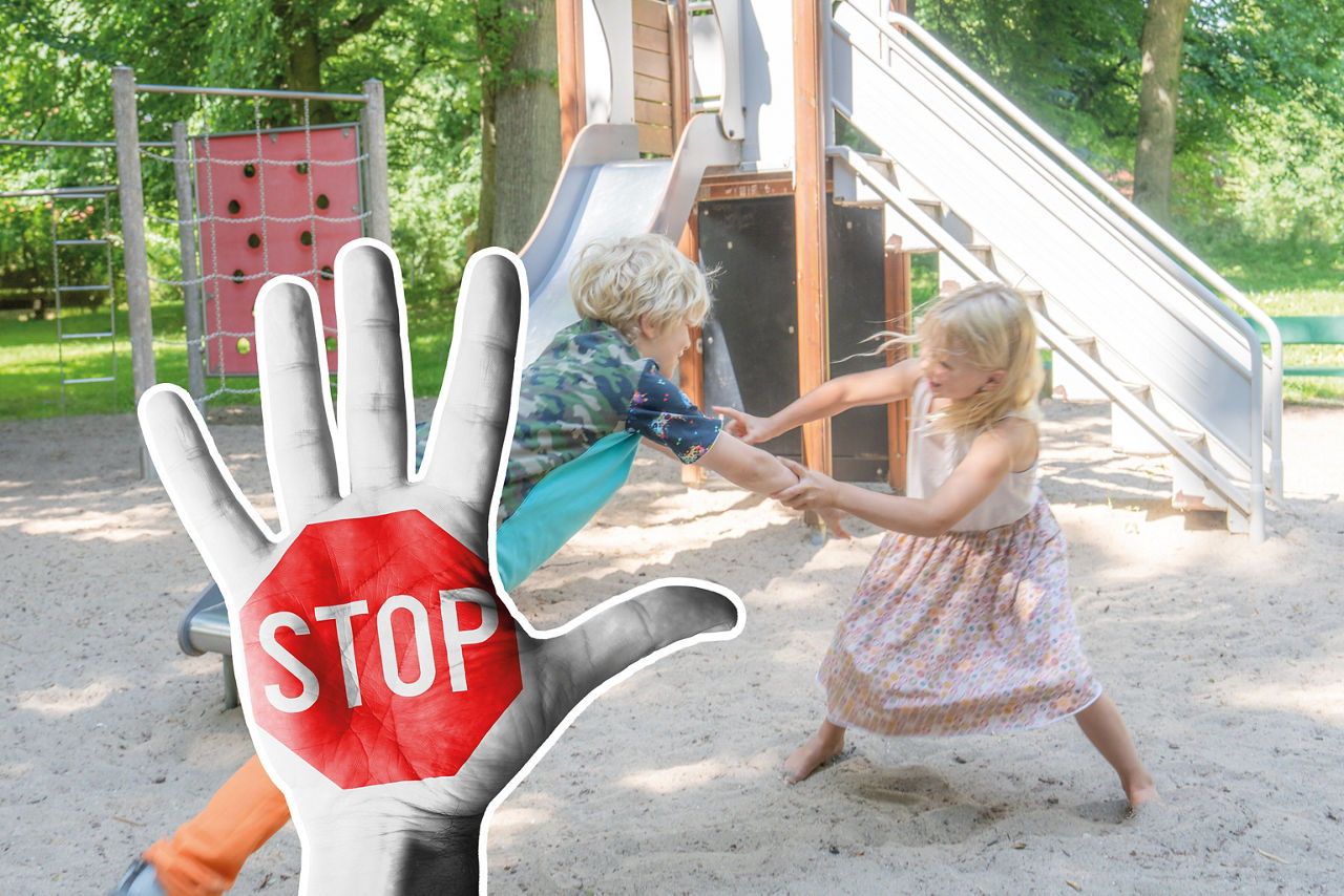 Rangelnde Kinder im Hintergrund und im Vordergrund eine Hand mit einem aufgemalten Stop-Schild