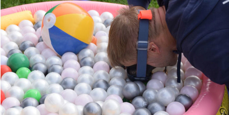 Stand vom Wassersportverein Schermbeck: Bällebad, in das  eine Person sein Gesicht mit einer Tauchmaske eintaucht