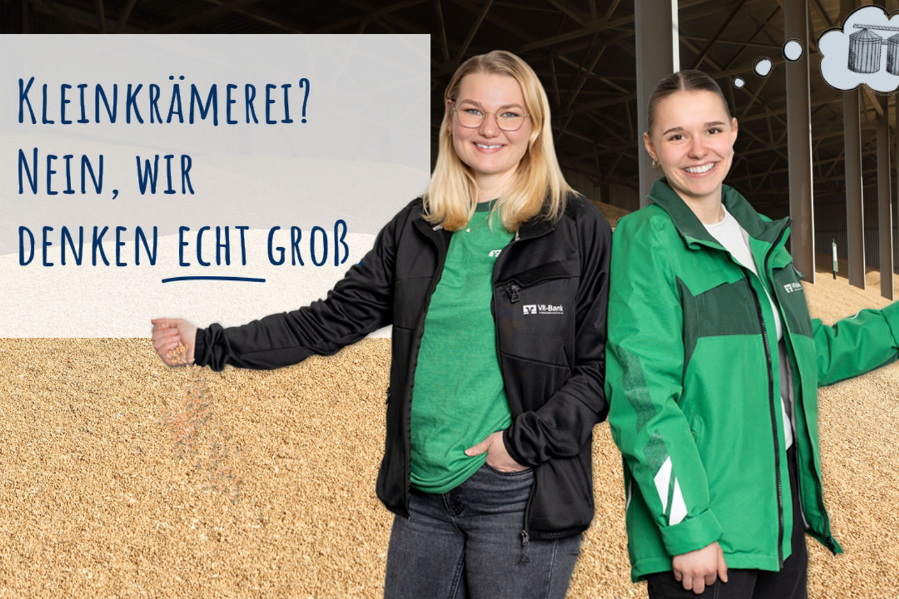 Zwei Azubis stehen vor einem Kornhaufen. Aus den Händen der Azubis rieseln ein paar Körner