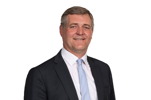 Freundlich lächelnder Mann im Anzug, unser Vorstand Manfred J. Gruber