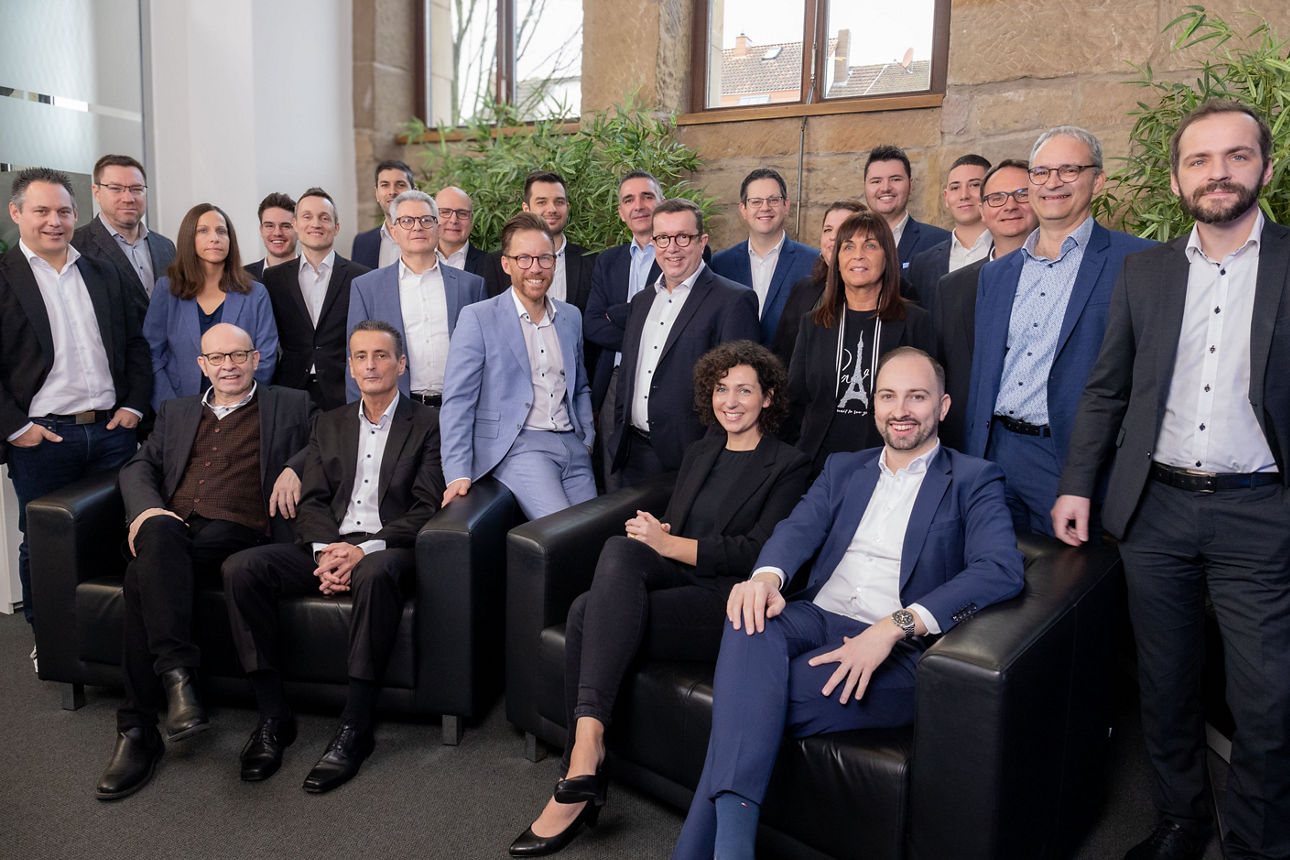 Männer und Frauen im Casual Business Look stehen und sitzen zusammen