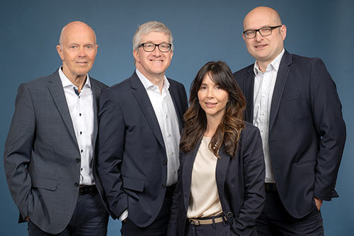 drei Männer und eine Frau auf einem Gruppenbild