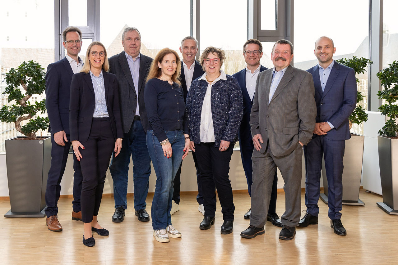Es handelt sich um ein Gruppenfoto des Aufsichtsrates der Volksbank Ruhr Mitte Stand März 2024. Es befinden sich 9 Personen  im Bild, 3 Frauen und 6 Männer, alle lächeln in die Kamera. 