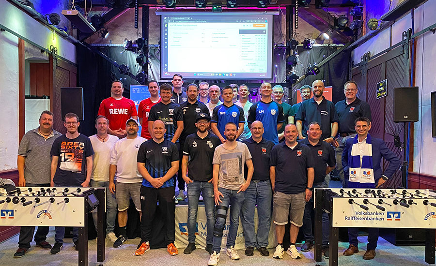 Das Bild zeigt ein Gruppenfoto vom VR Kicker Cup in der Kulturhalle Stockheim. Teilnehmer lächeln stolz.
