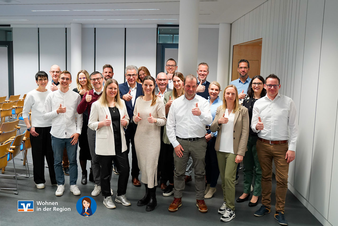 Menschen stehen in einer Gruppe und halten den Daumen hoch