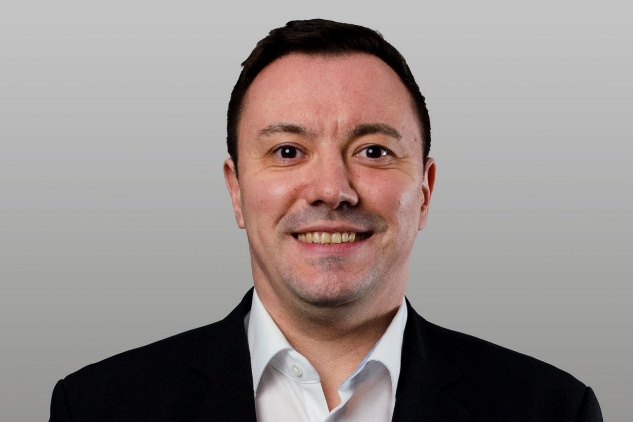 Privatkundenberater Christian Hörhager vor grauen Hintergrund