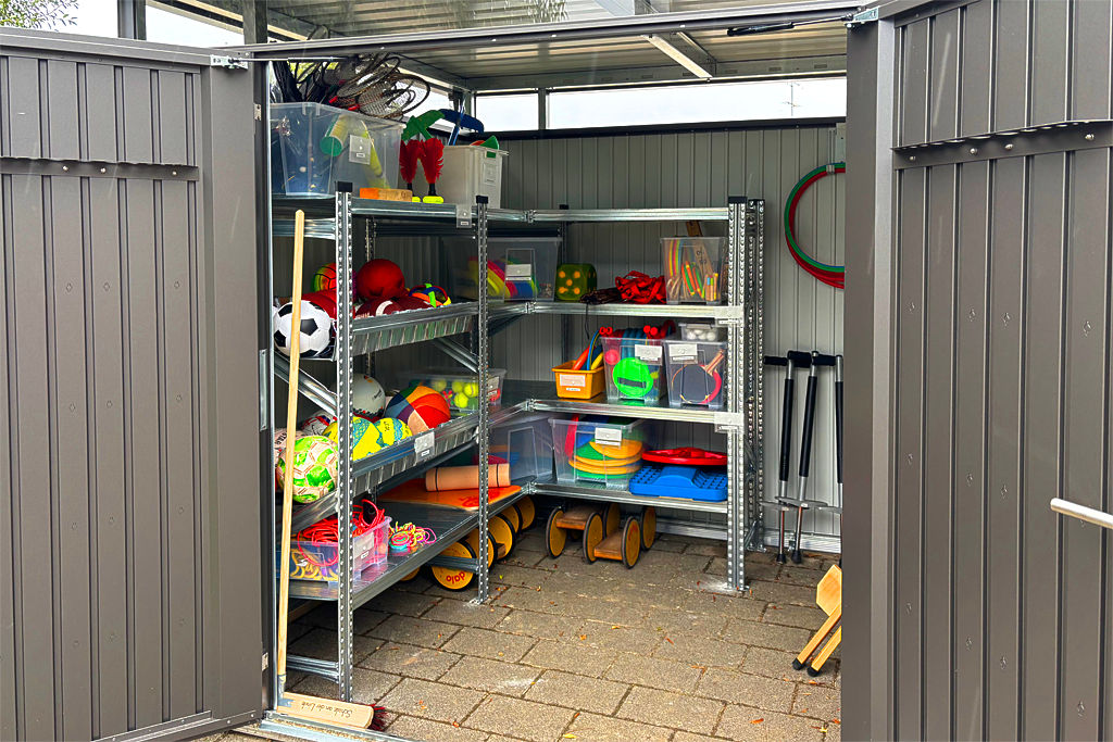 Offene Spielgerätehütte mit Einblick auf die Spielgeräte
