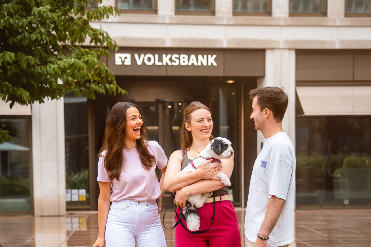 Drei Personen vor dem Bankgebäude