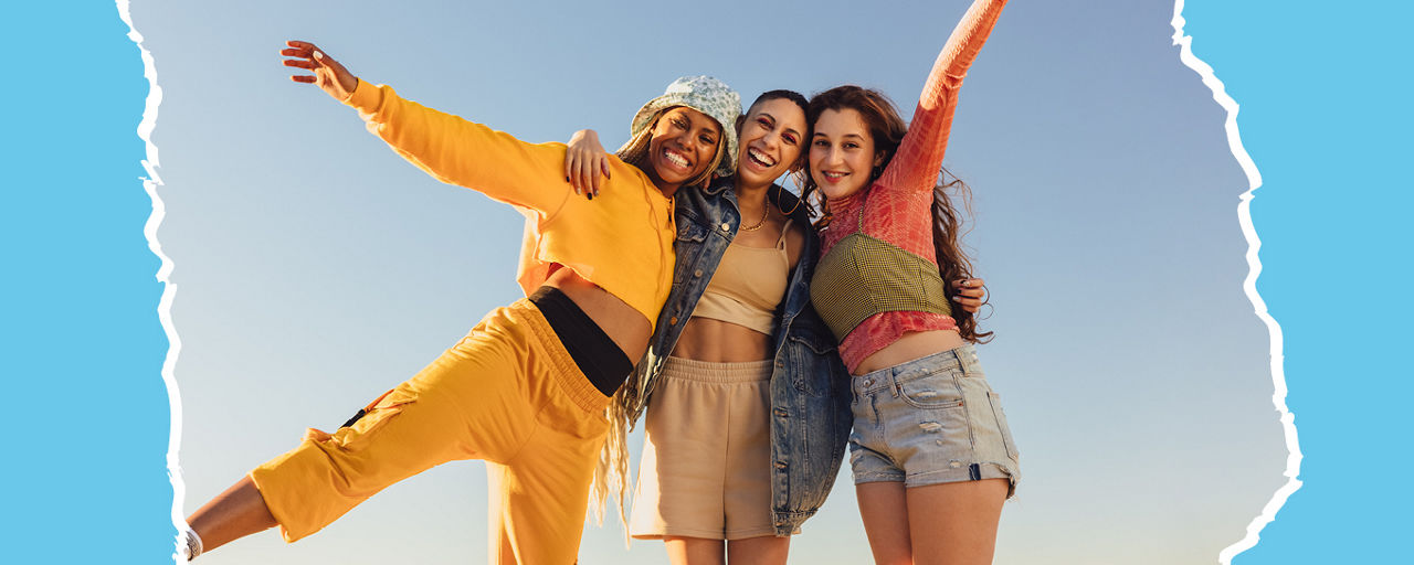 3 Frauen liegen sich in den armen und lachen
