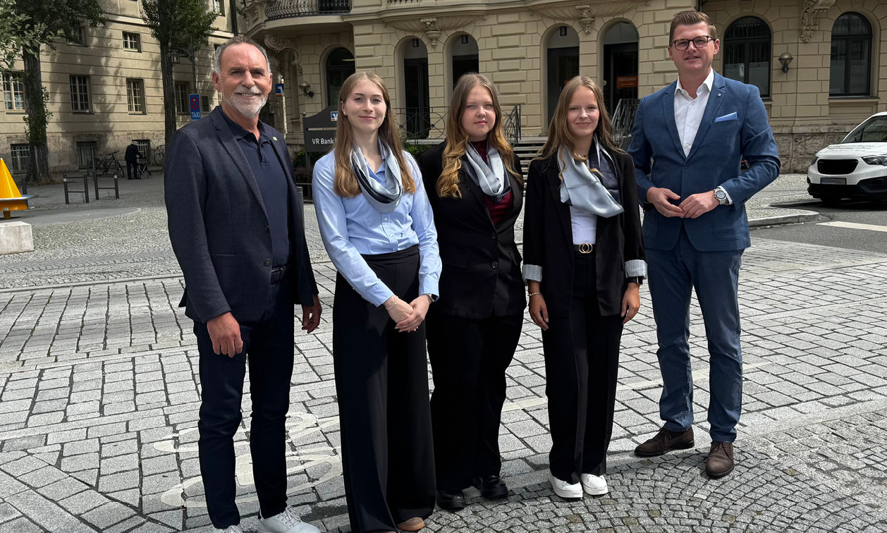 zwei Vorsände und drei neue Auszubildende stehen vor unserer Hauptstelle