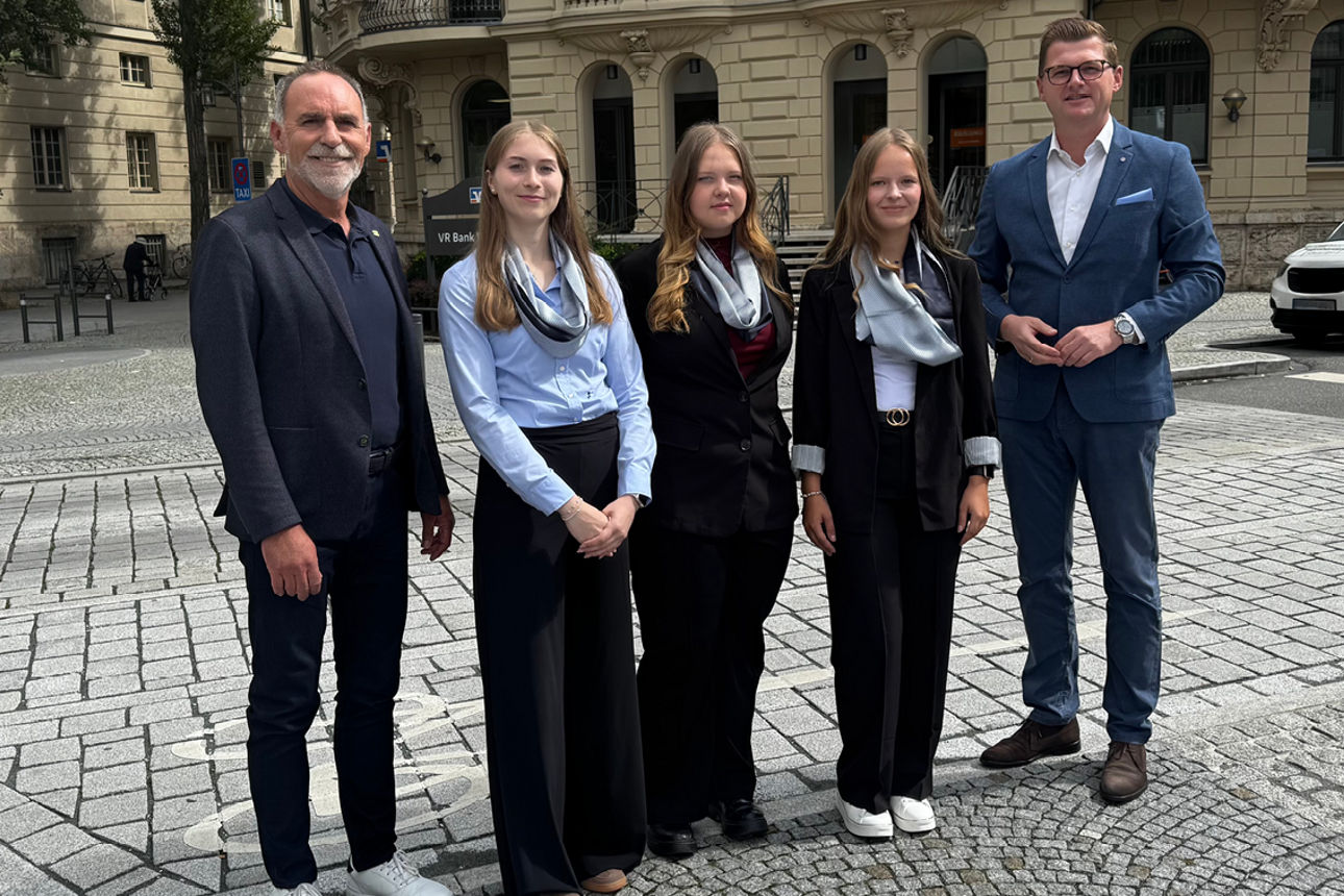 Vorstand und Auszubildende stehen vor unserer Hauptstelle