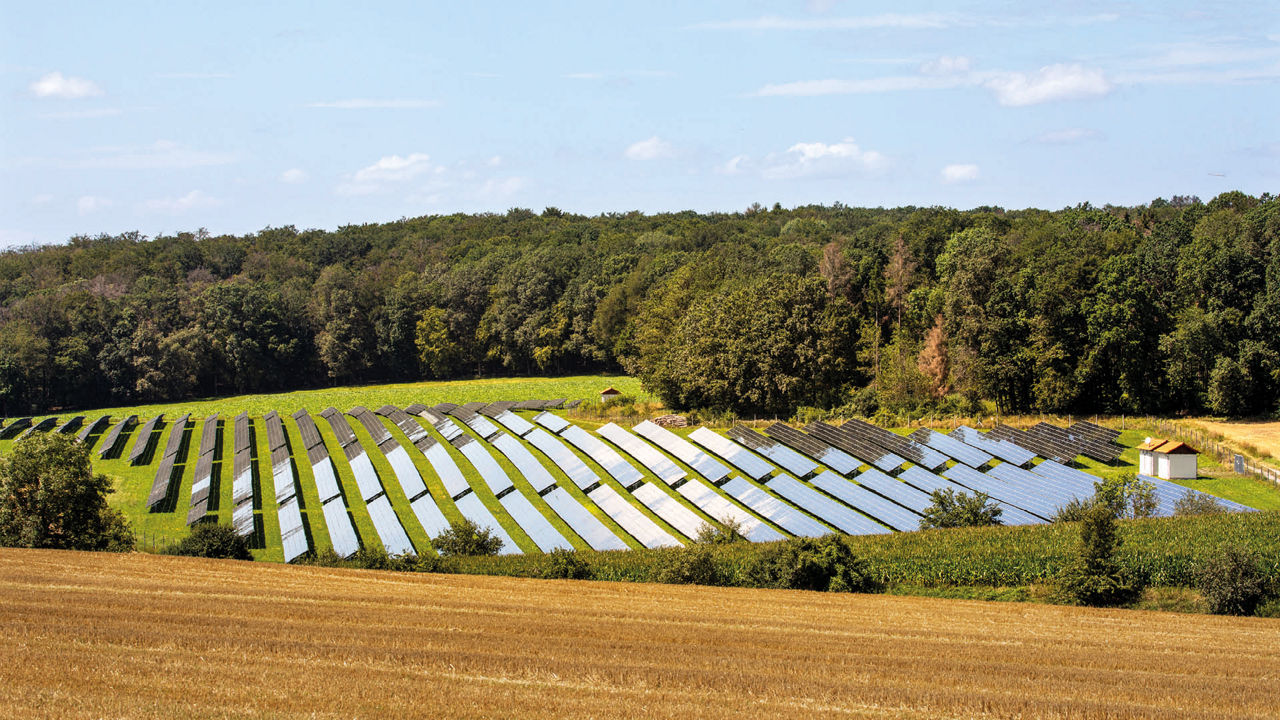 Eine Landschaft mit blauem Himmel und Solaranlagen auf dem Feld. 