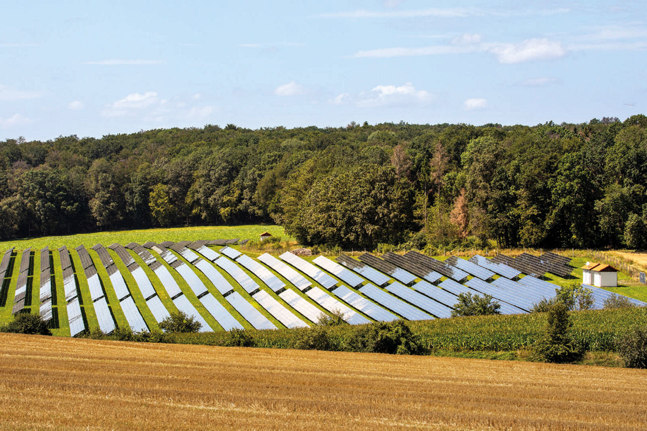 Eine Landschaft mit blauem Himmel und Solaranlagen auf dem Feld. 