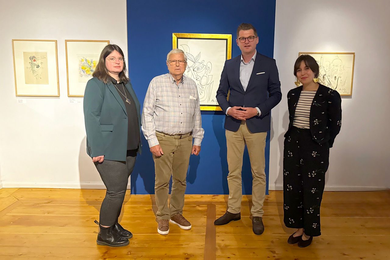 mehrere Frauen und Männer stehen im Ausstellungsraum
