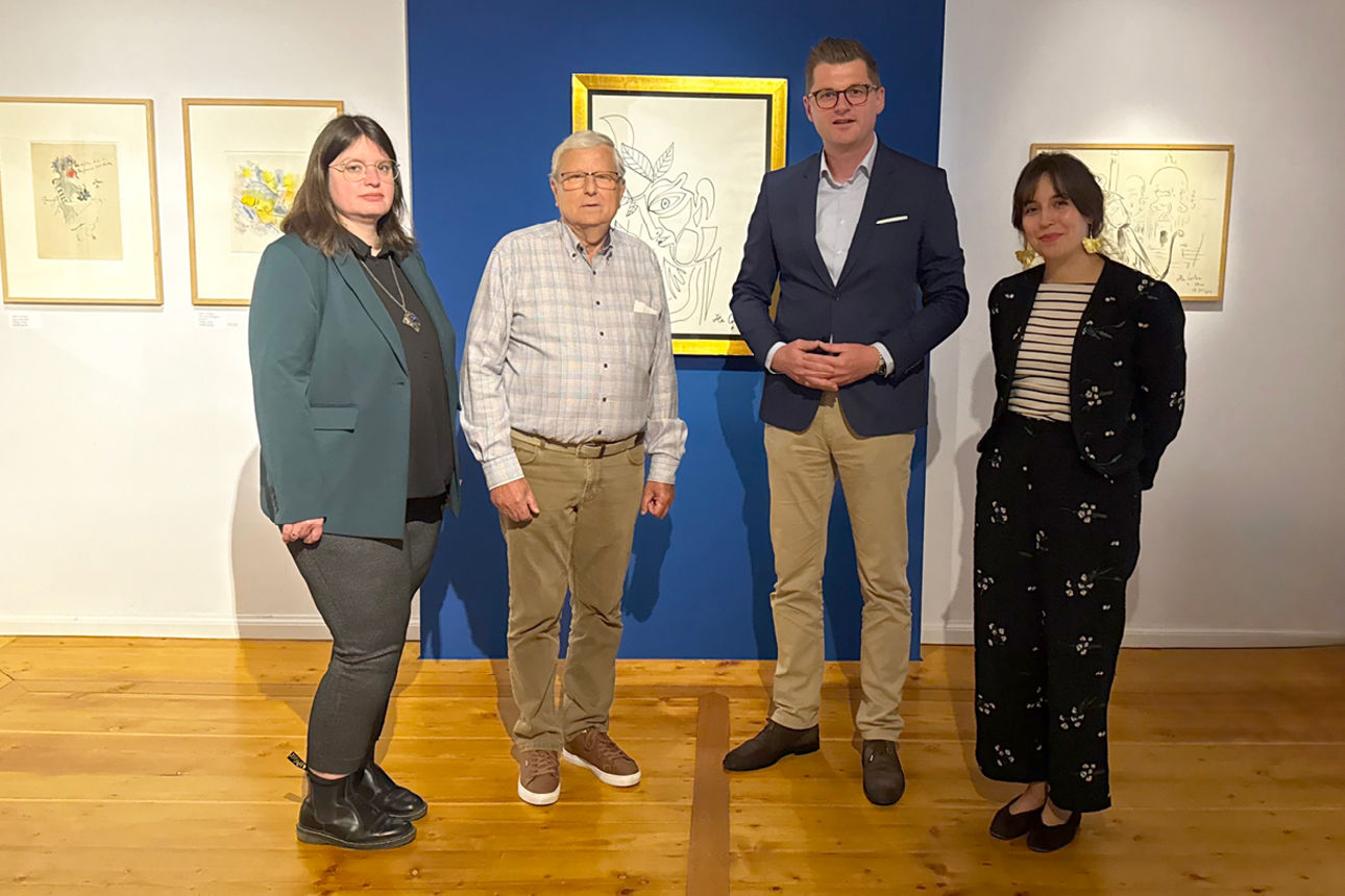 mehrere Frauen und Männer stehen im Ausstellungsraum