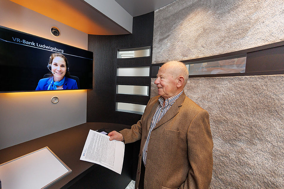 Kunde in einer VR-SISy Filiale im Gespräch mit einer Mitarbeiterin der Bank 