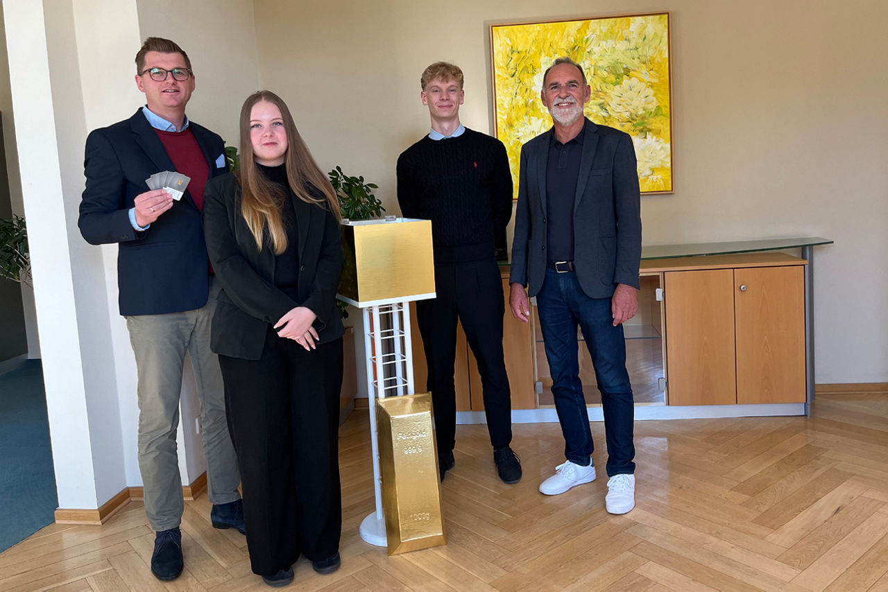 Vorstand der VR Bank Weimar und zwei Auszubildende stehen vor der Losbox.