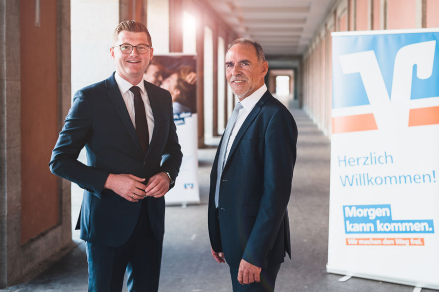 Vorstände der Bank stehen vor dem Bankgebäude