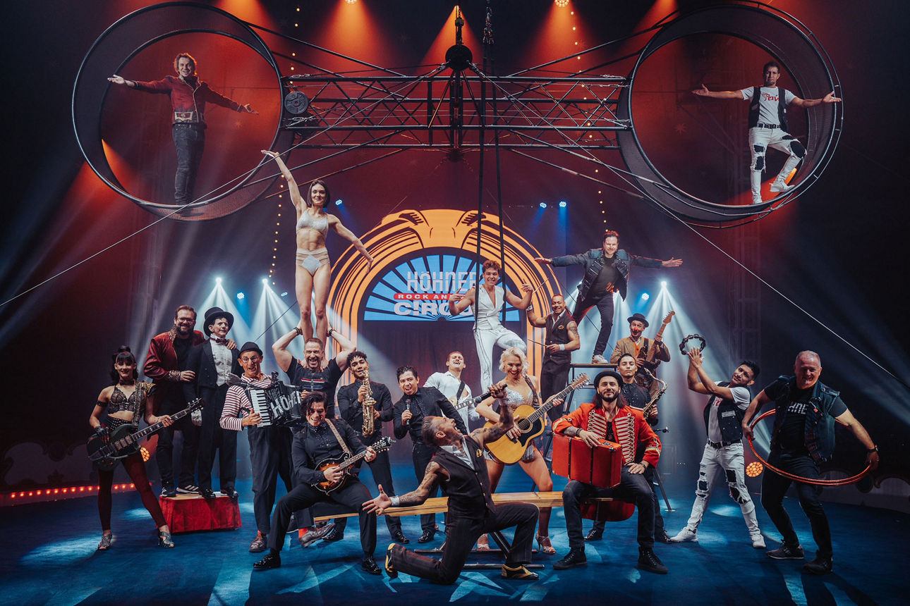 Eine Gruppe von Artisten stehen zusammen mit der Band Höhner in einer Manege