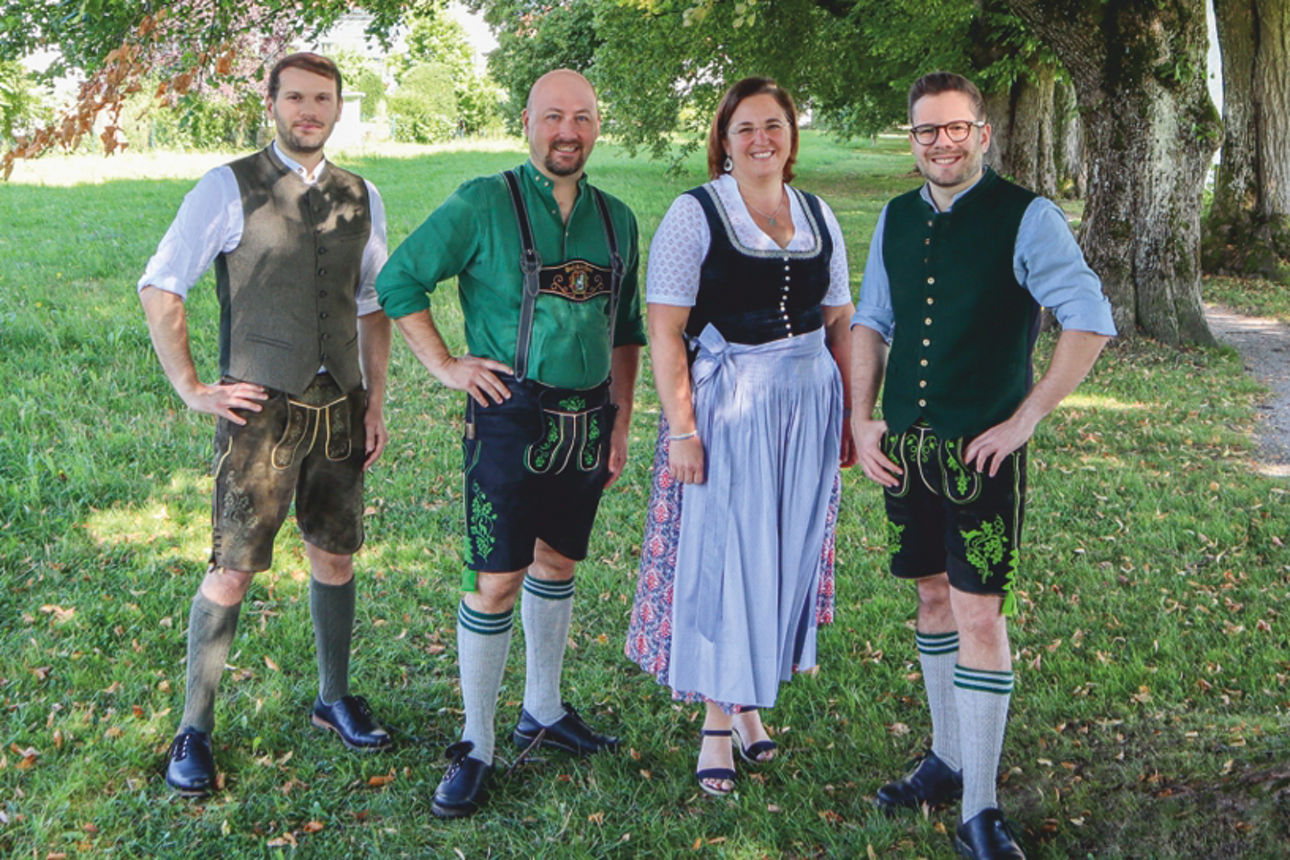 4 Experten des Teams Hausverwaltung und Immobilien stehen auf einer Wiese