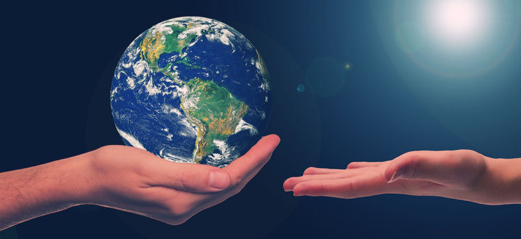 Die eine Hand überreicht der anderen eine Weltkugel