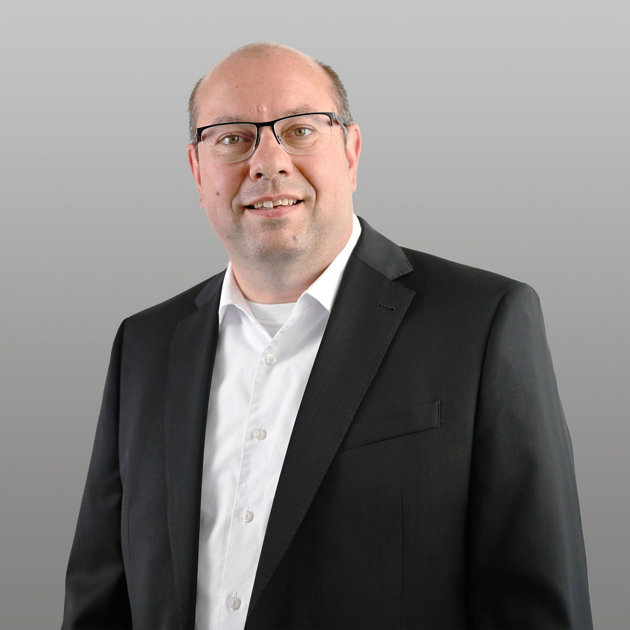 Geschäftskundenberater Marco Hagedorn vor grauem Hintergrund