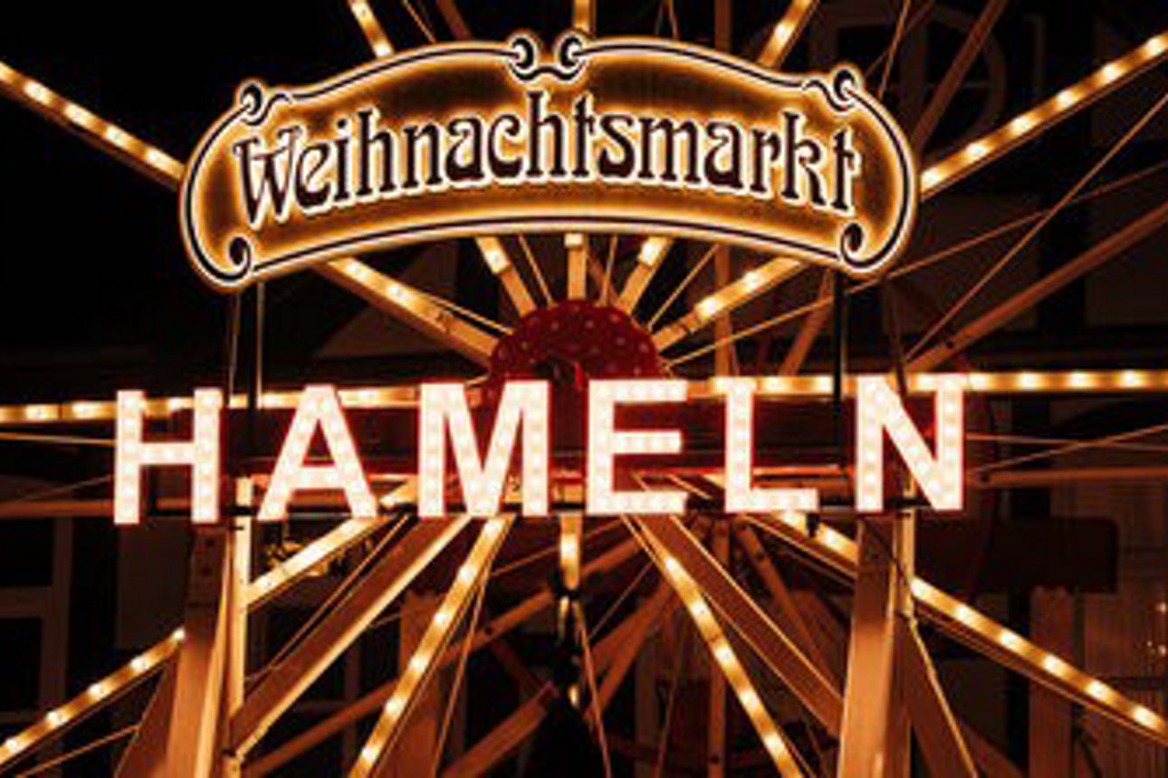 Eine große, beleuchtete Weihnachtspyramide und ein dekorierter Weihnachtsbaum.