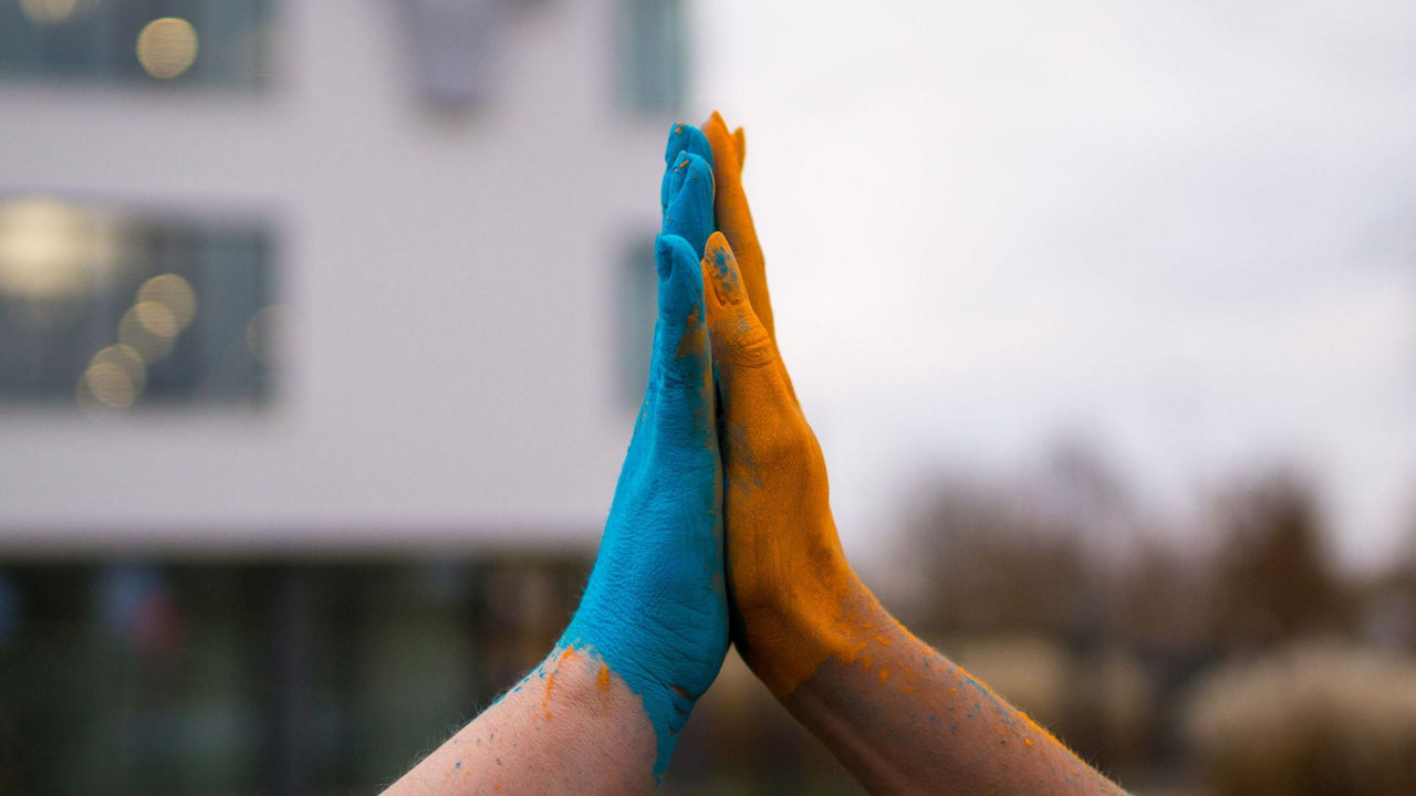 Handschlag in Farbem Blau Orange