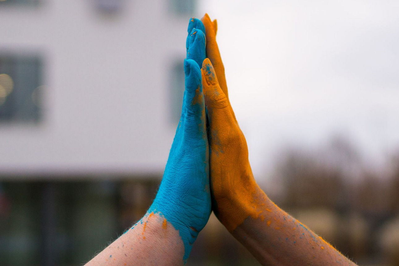 Handschlag in Farbem Blau Orange