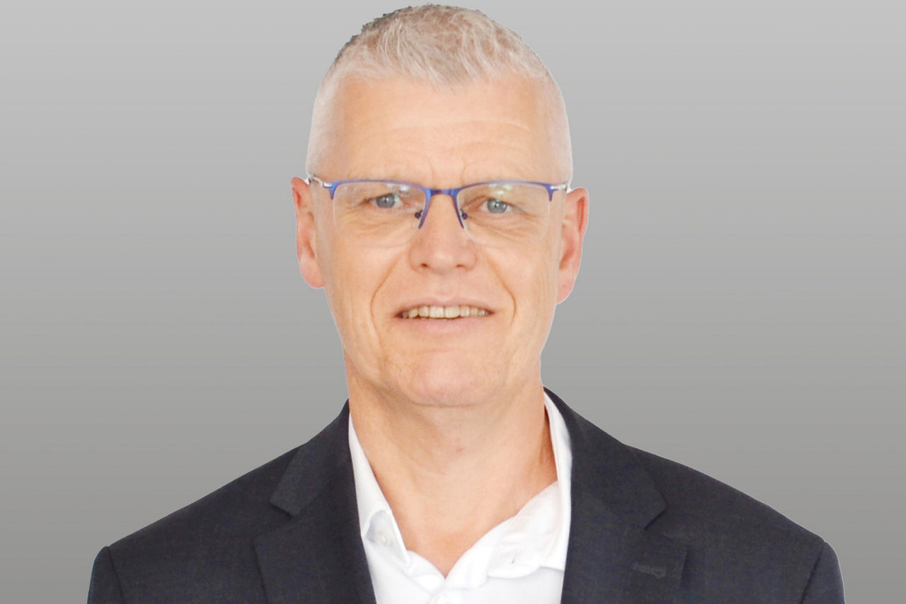 Privatkundenberater Andreas Hanisch vor grauen Hintergrund