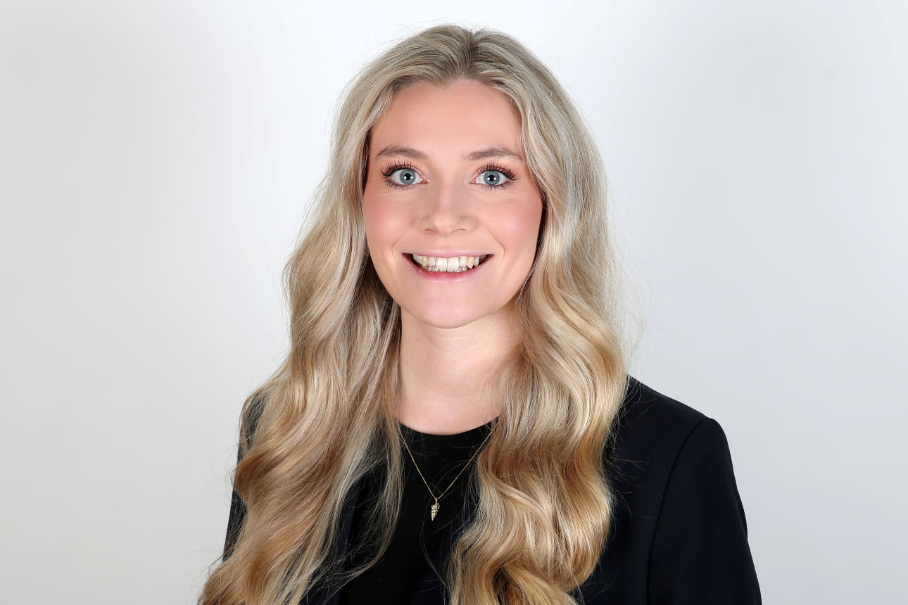 Eine lächelnde Frau schaut in die Kamera.