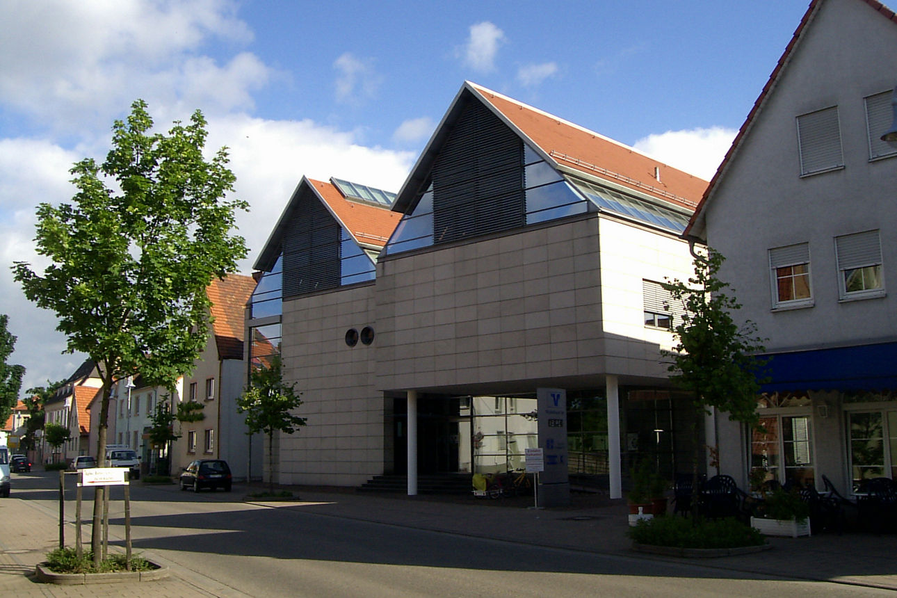 Zwei Männer und eine Frau stehen lachend vor einer blauen Wand