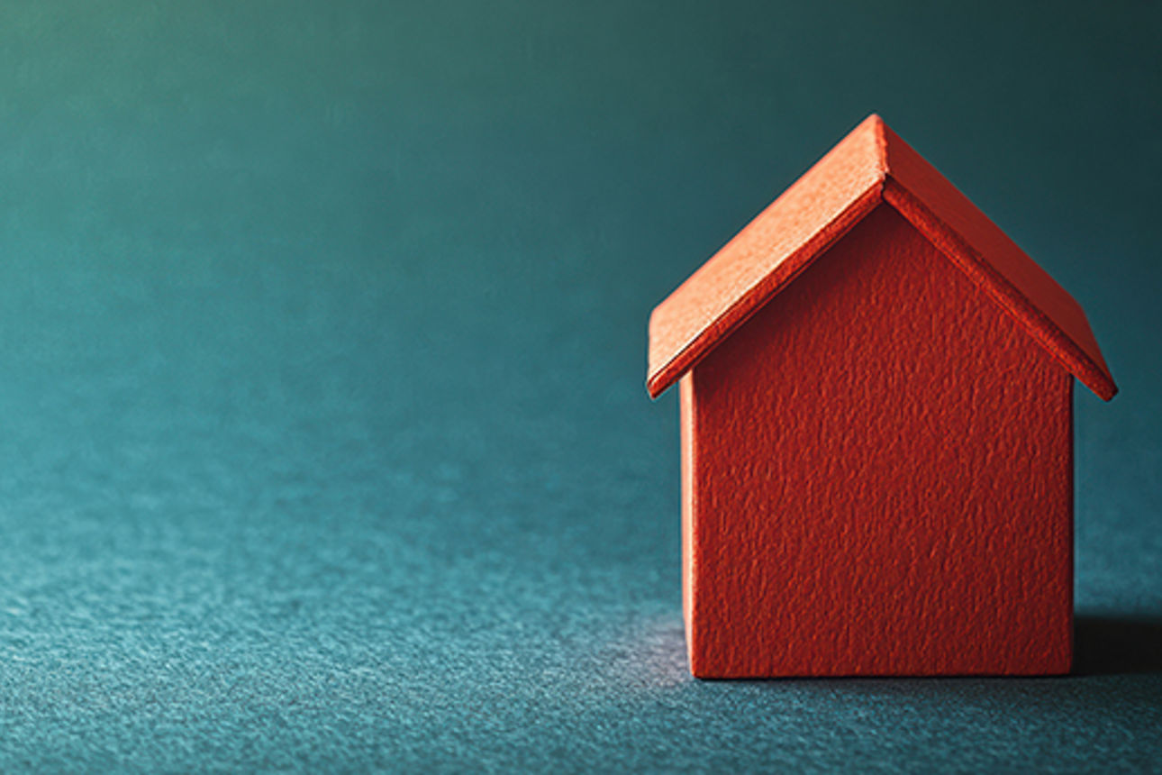Haus-Grafik in rot vor blau-türkisem Hintergrund