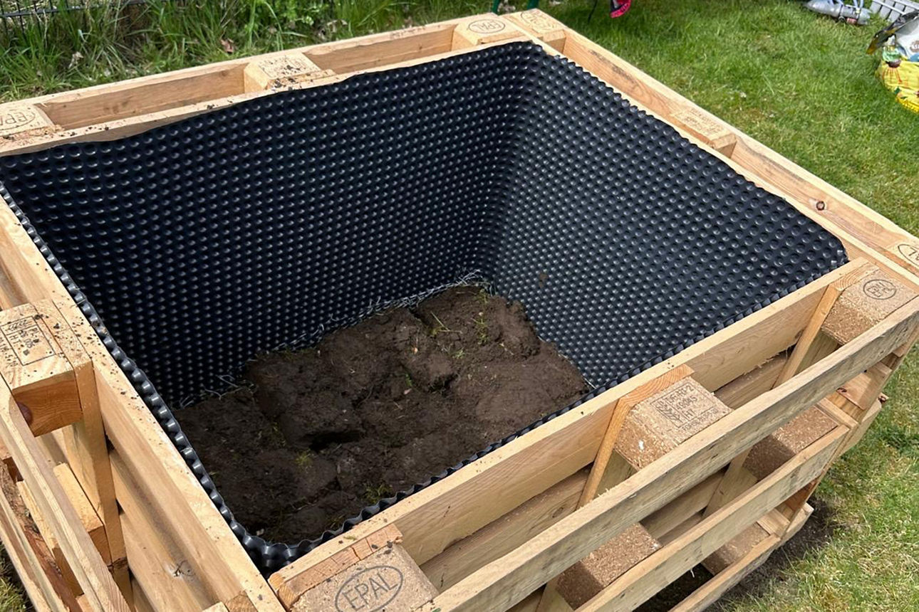 Ein Hochbeet wird mit Erde angefüllt.